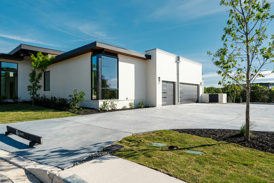 Residential concrete driveway leading to a modern home, illustrating seasonal concrete maintenance